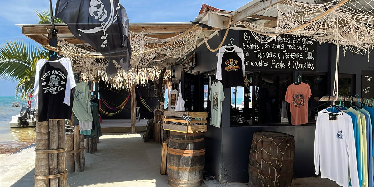 Outdoor Pirate themed clothing store with merchandise displayed under a thatched roof palapa by the beach on Caye Caulker in Belize