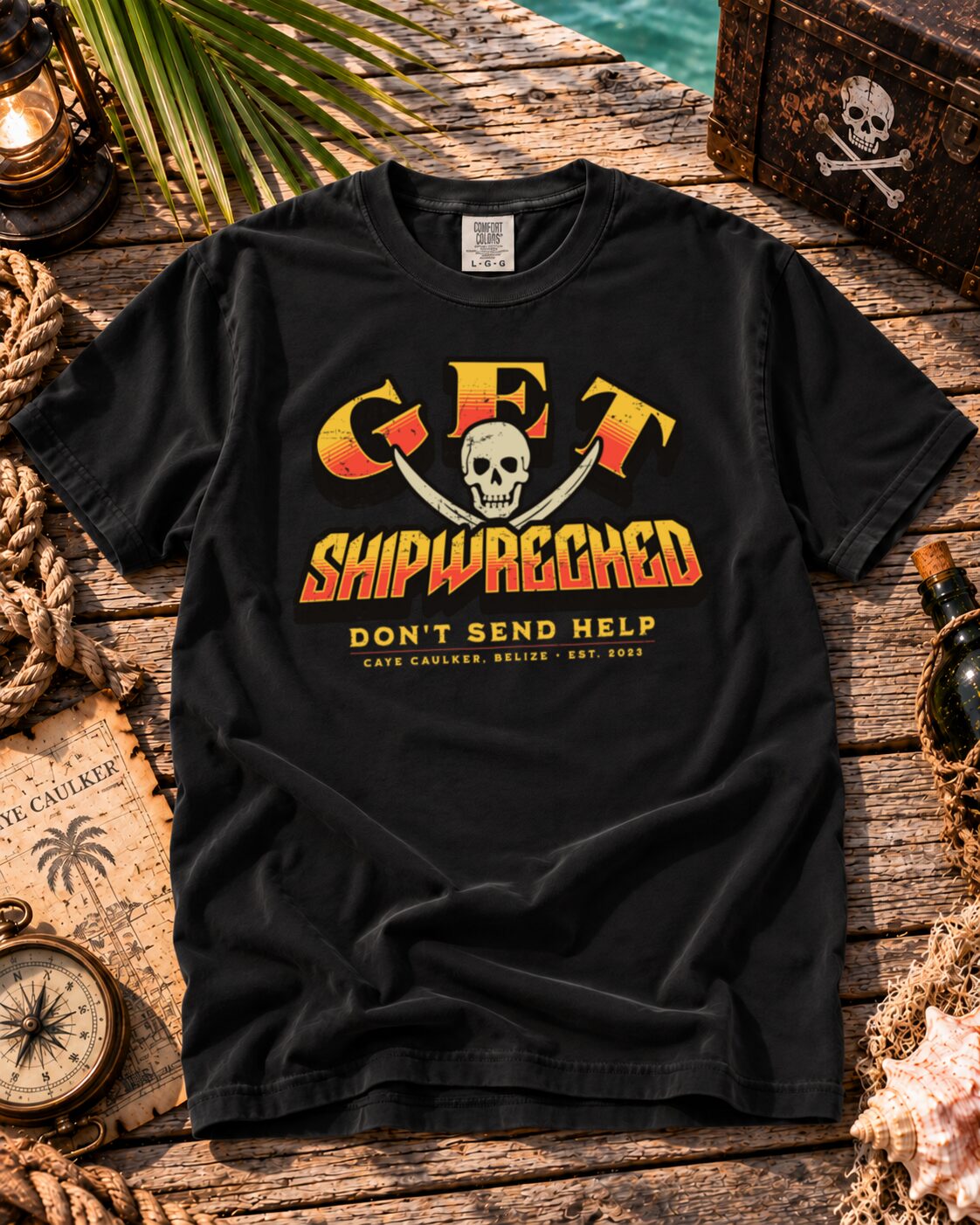 Black Get Shipwrecked Rocker Tee flat lay with orange and yellow skull-and-cutlasses artwork
