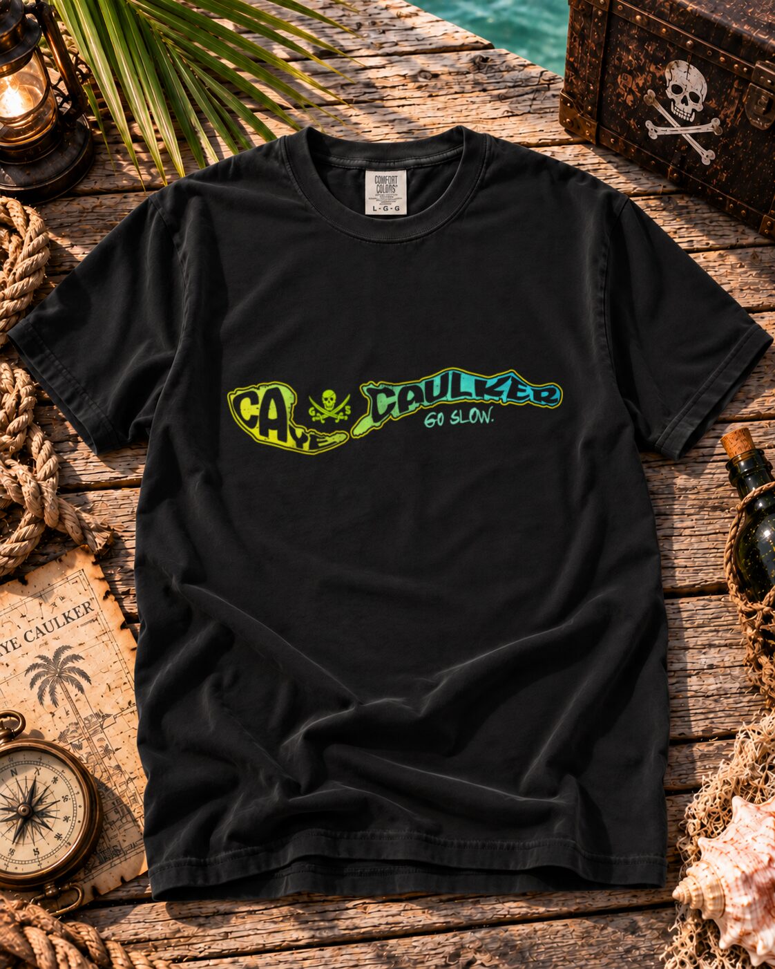 Black Caye Caulker Vibin Tee flat lay with lime-to-teal island map artwork and Go Slow lettering