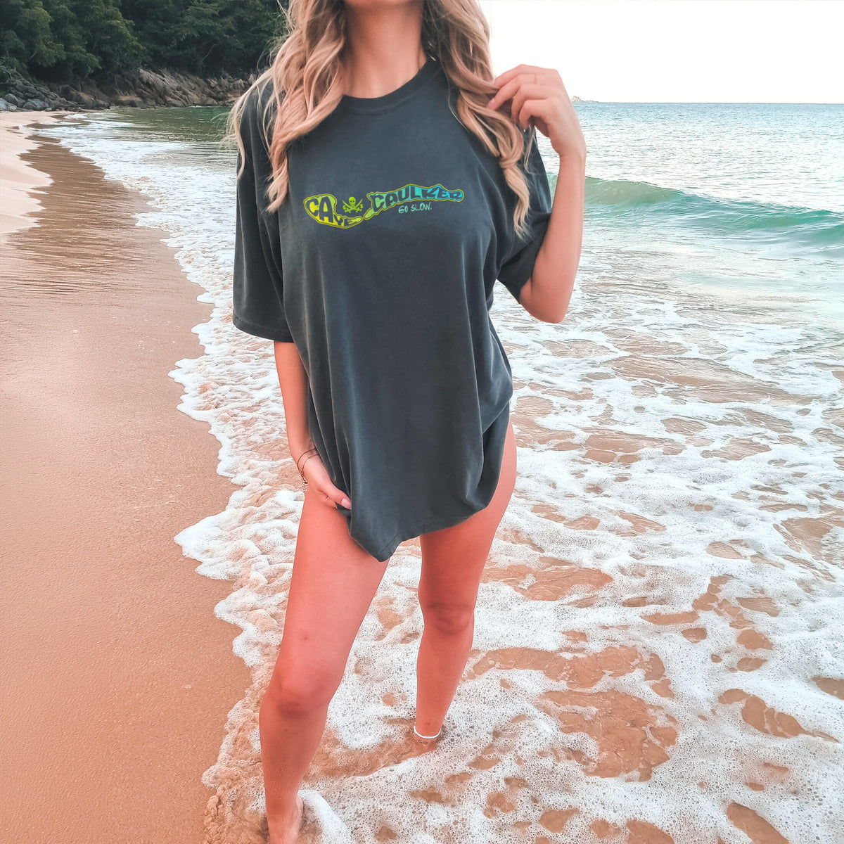 Model wearing the Pepper Caye Caulker Vibin Tee with lime-to-teal island map artwork and Go Slow lettering